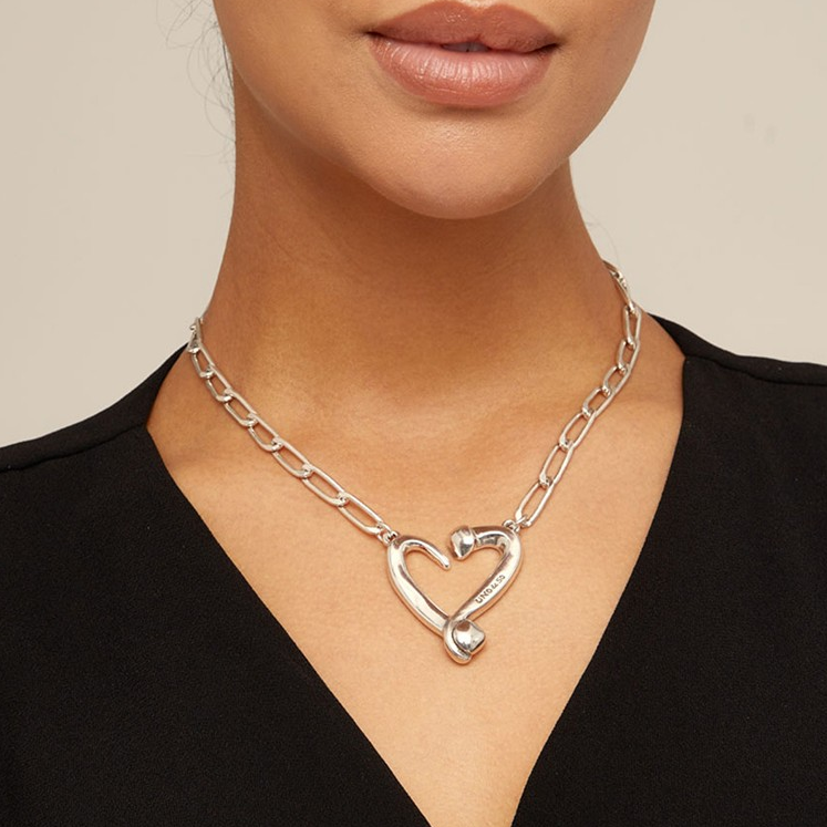 Uno de 50 Necklance Silver heart necklace on a person, complementing a black top.